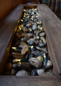 In the centre of the table, I put river rocks and fairy lights. The lights add soft light at night. 